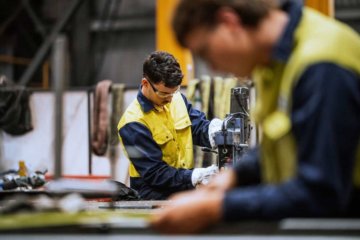 Technician working on industrial automation equipment in a manufacturing facility.